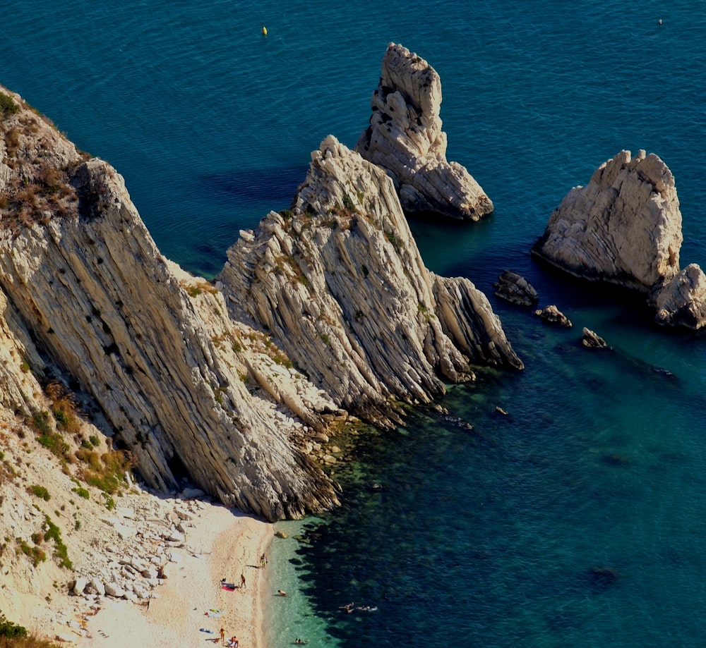 an aerial view of a rocky beach with clear blue water