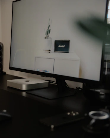A sleek dark-themed office space with gold accents and a glowing AI interface on screen.