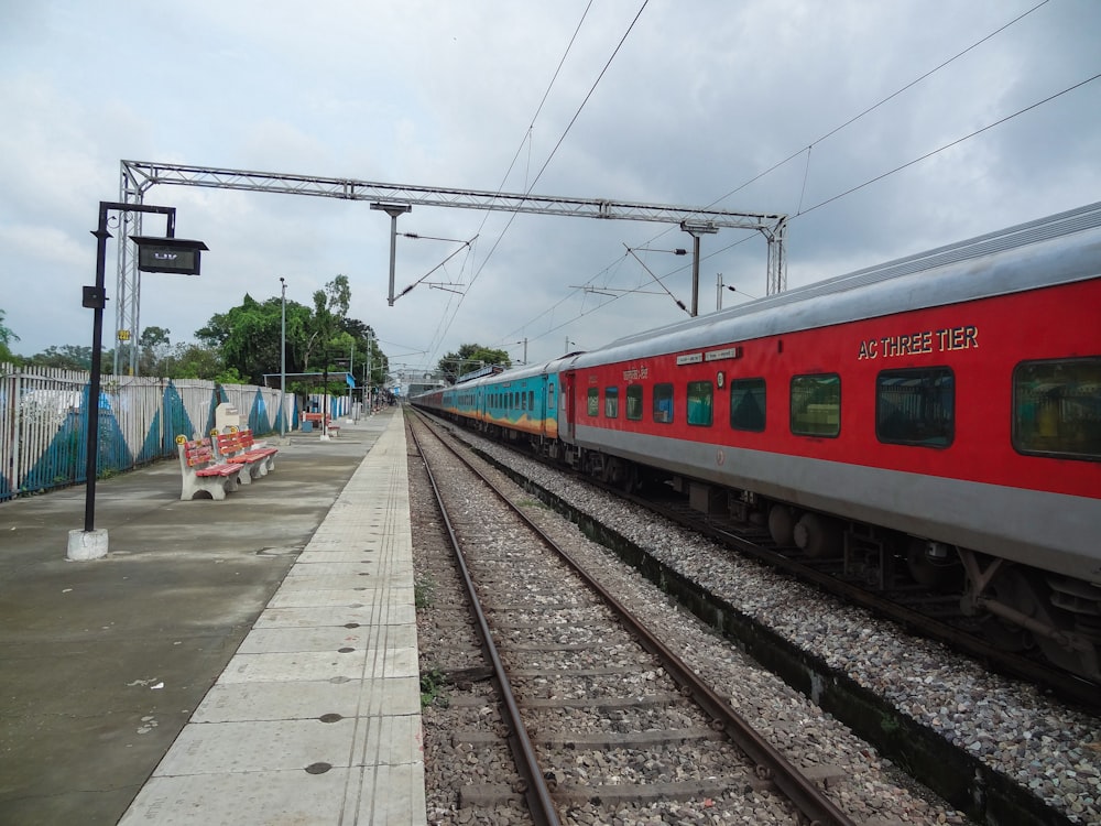 a red and silver train traveling down train tracks