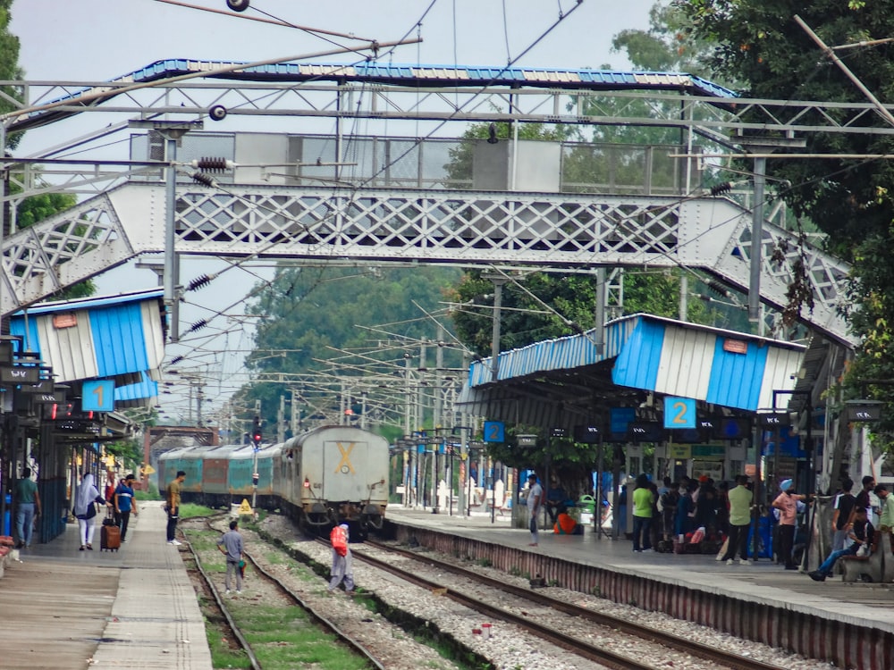 a group of people standing on the side of a train track