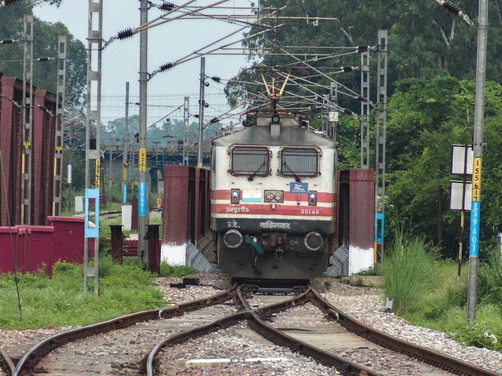 a train traveling down train tracks next to a forest