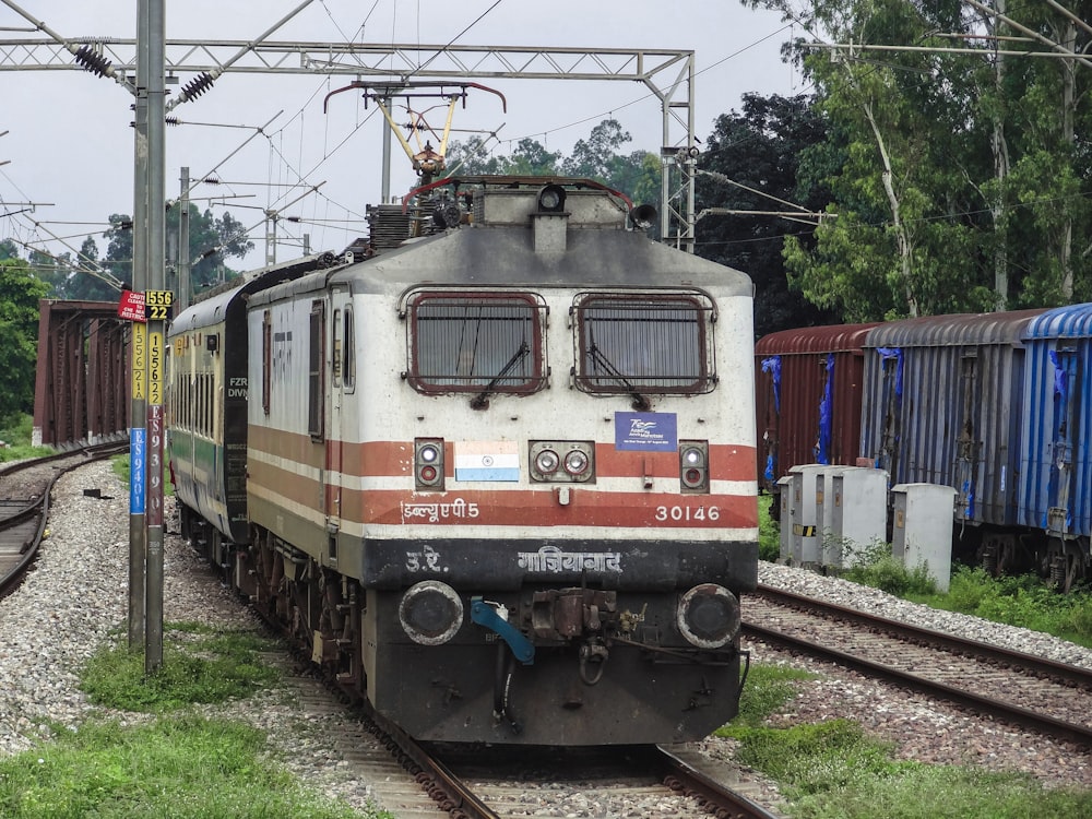 a train traveling down train tracks next to a forest