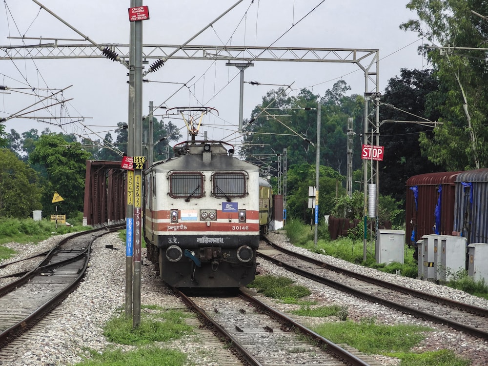 a train traveling down train tracks next to a forest