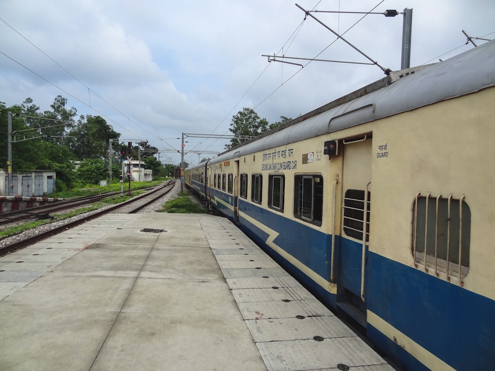 a blue and white train sitting at a train station