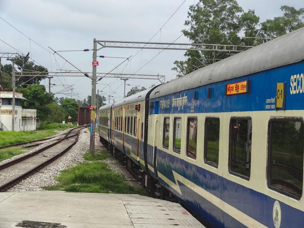 a blue and white train traveling down train tracks