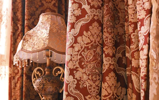 a lamp sitting on top of a table next to a window