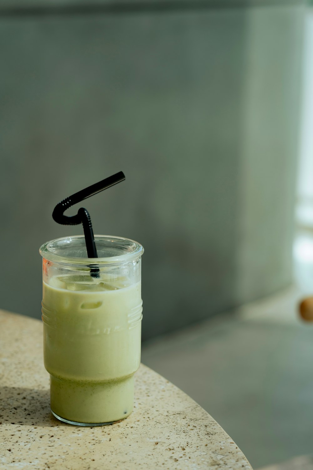 a glass with a straw in it sitting on a table