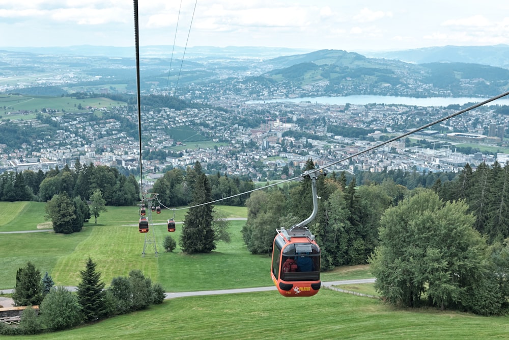 a cable car going up a hill with a view of a city