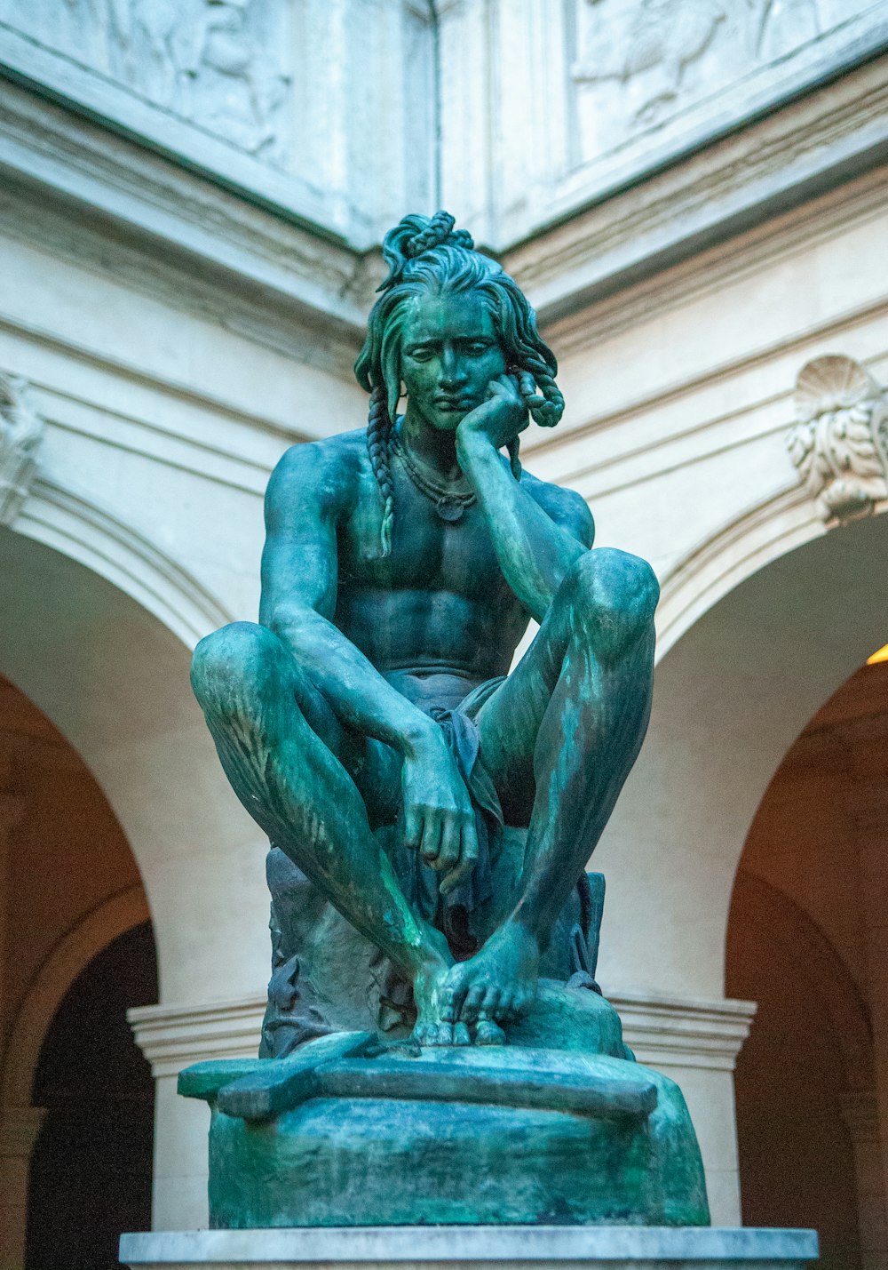 a statue of a man sitting on top of a table