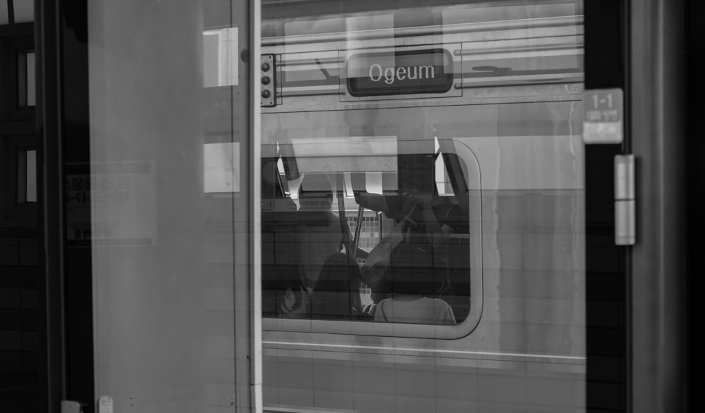 a reflection of a person in a train window