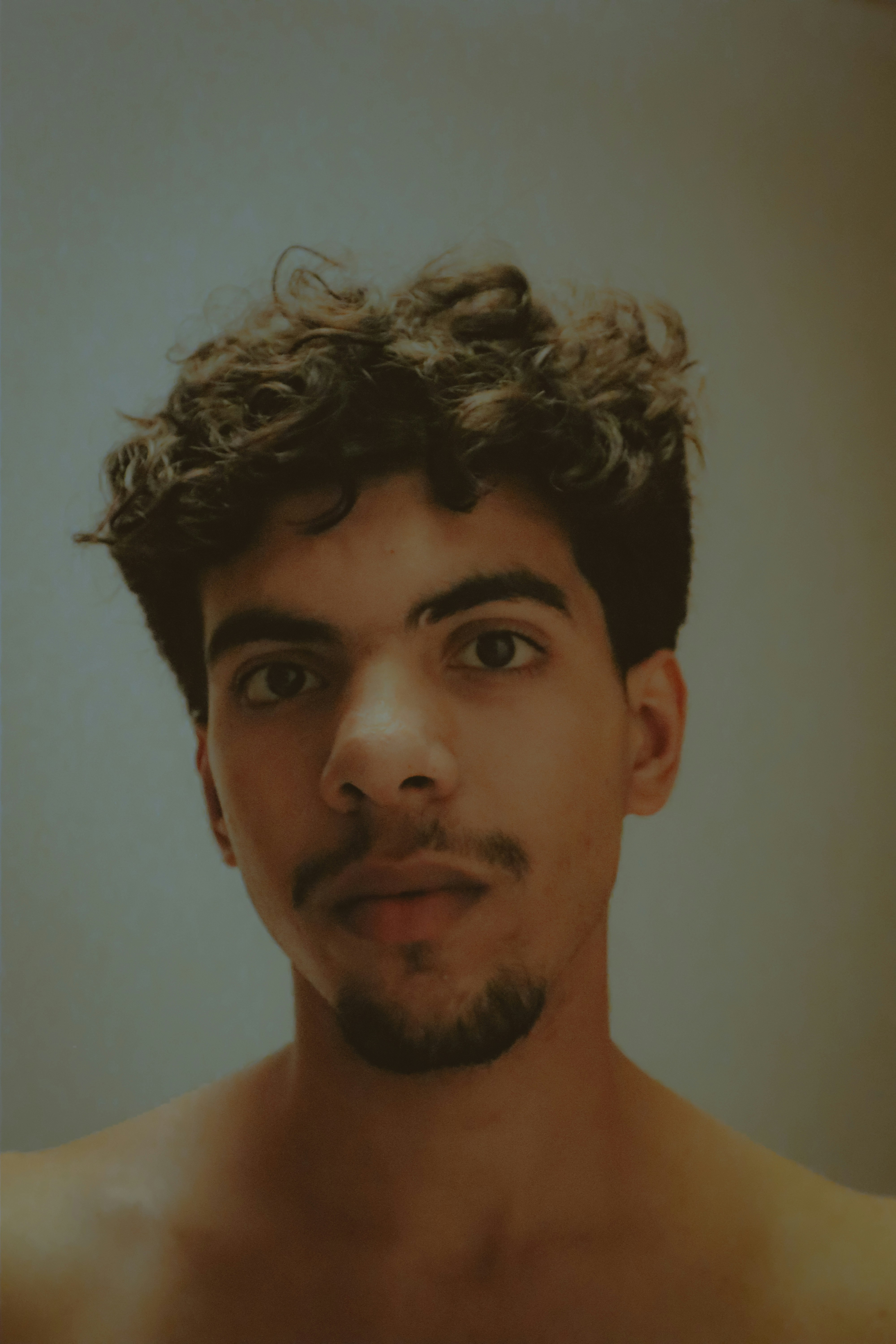 a man with curly hair and a mustache