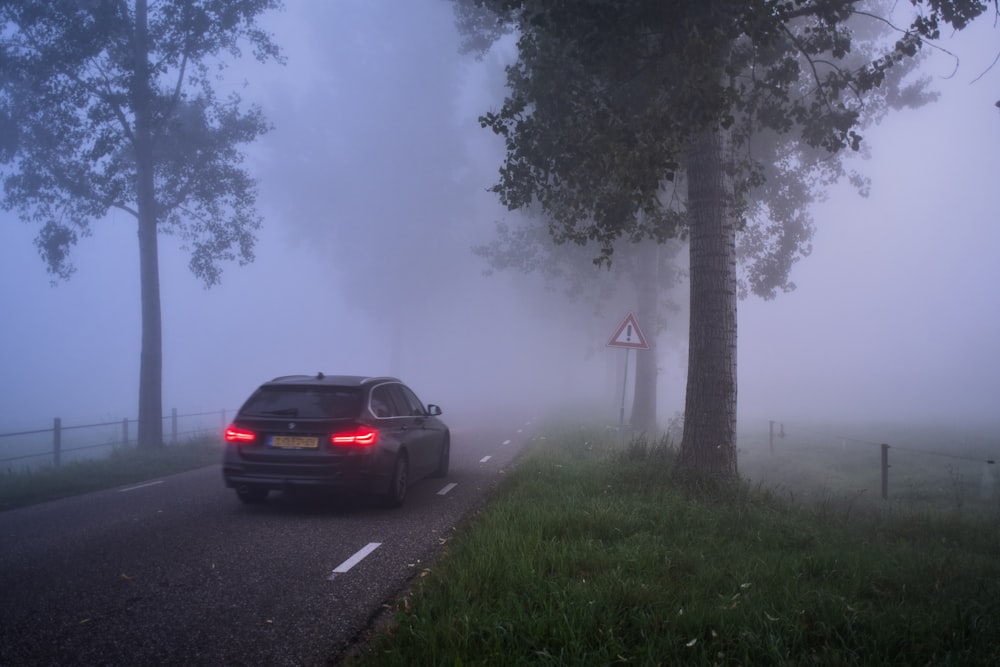 a car driving down a road in the fog