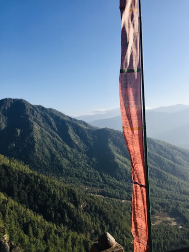 a view of a mountain range with a red flag in the foreground