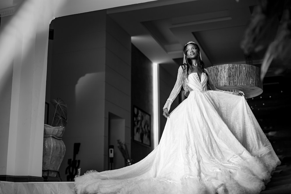 a woman in a wedding dress standing in a room
