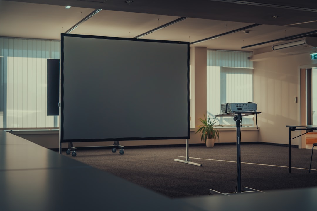 a large screen in an empty room with chairs,