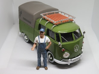 a toy man standing next to a green van