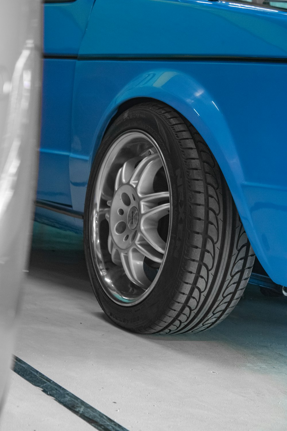 a close up of a tire on a blue car