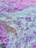 An abstract composition featuring a mixture of vibrant colors and textures resembling a fluid or liquid surface with swirls and patterns. The colors blend into each other, creating an impression of movement and energy.