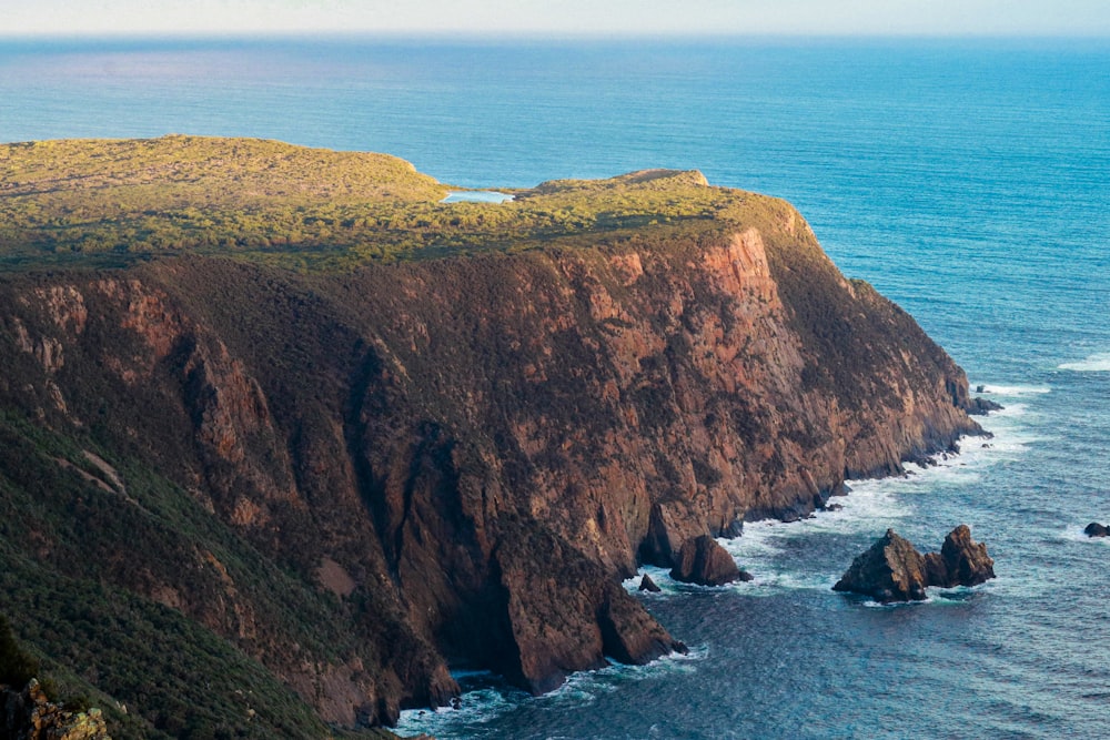 a large body of water next to a rocky cliff