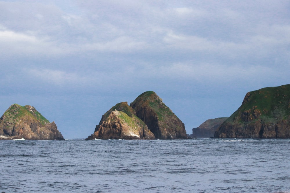 a group of rocks in the middle of a body of water