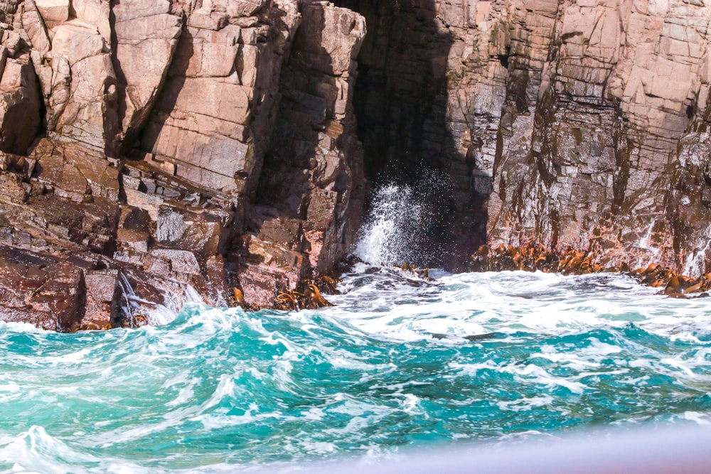 a group of people standing on top of a cliff next to the ocean