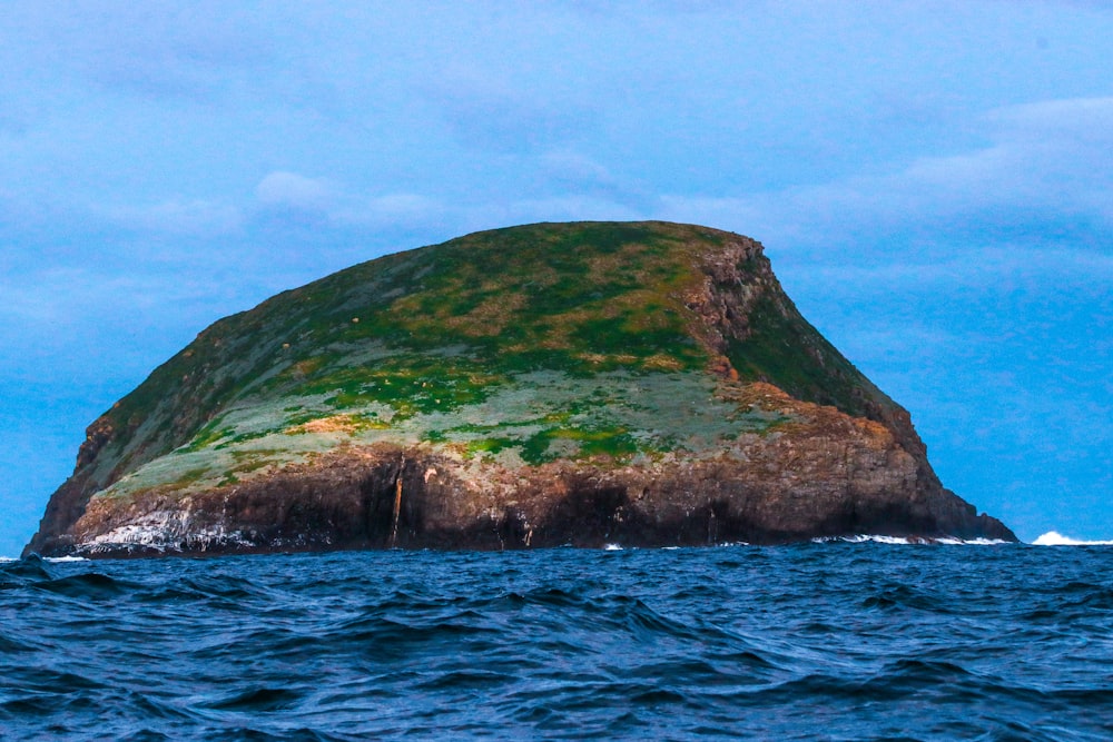 a large rock in the middle of the ocean