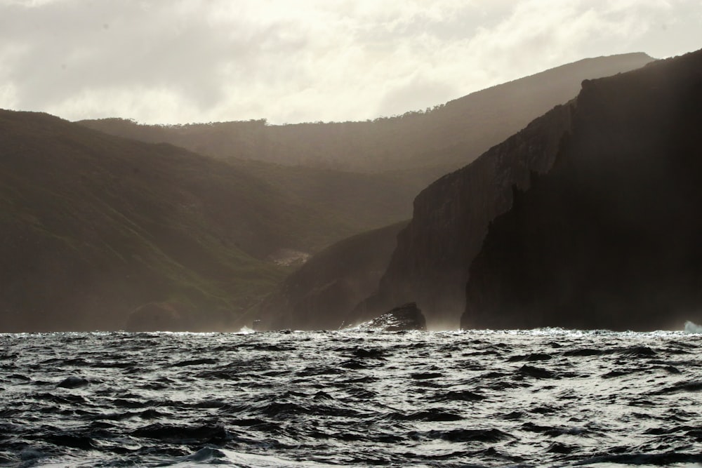 a large body of water with mountains in the background