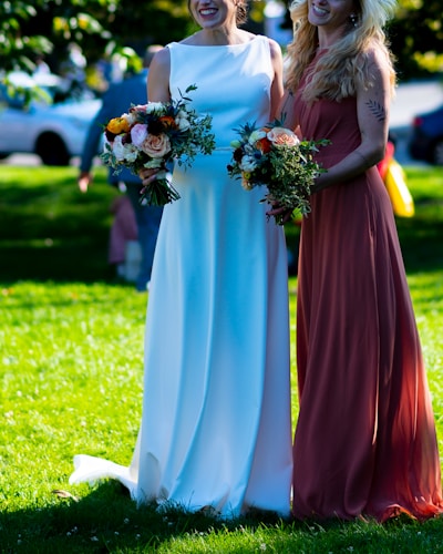 a couple of women standing next to each other on a lush green field