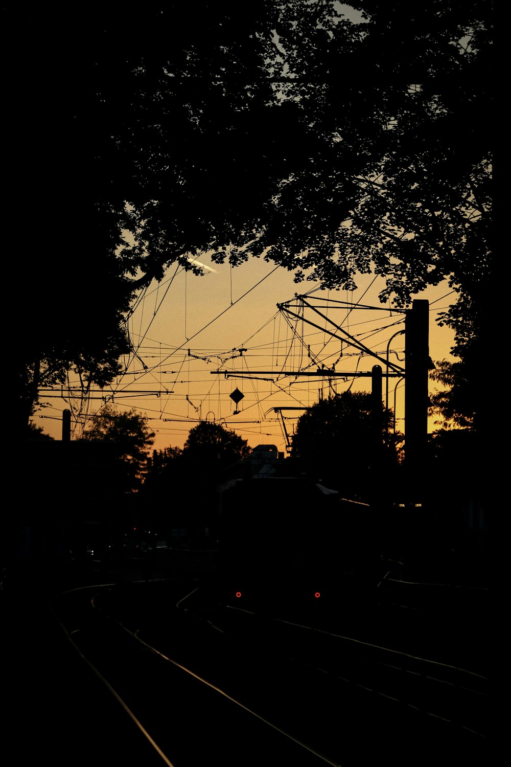 the sun is setting over a train track