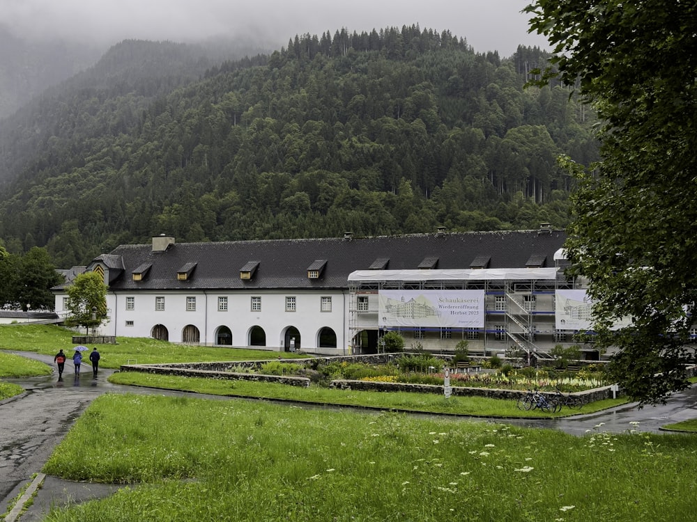 a large white building sitting in the middle of a lush green field