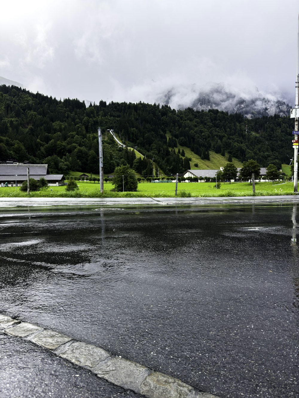 a wet street with a mountain in the background