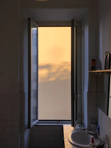 Sparkling bathroom with a bottle of disinfectant and soft natural light.