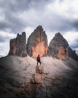 An adventurous hiker standing atop a mountain peak.