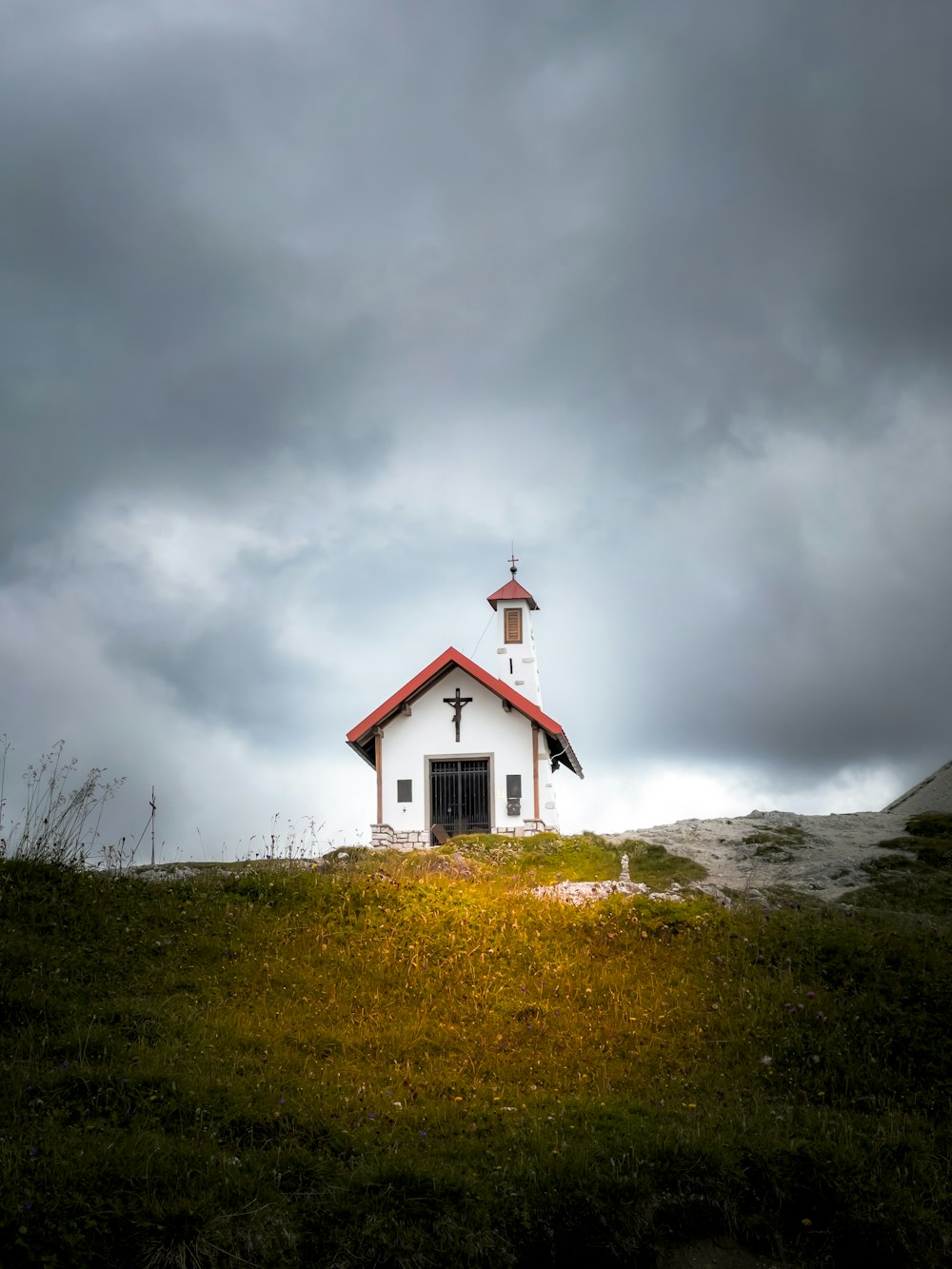 Una pequeña iglesia en una colina bajo un cielo nublado