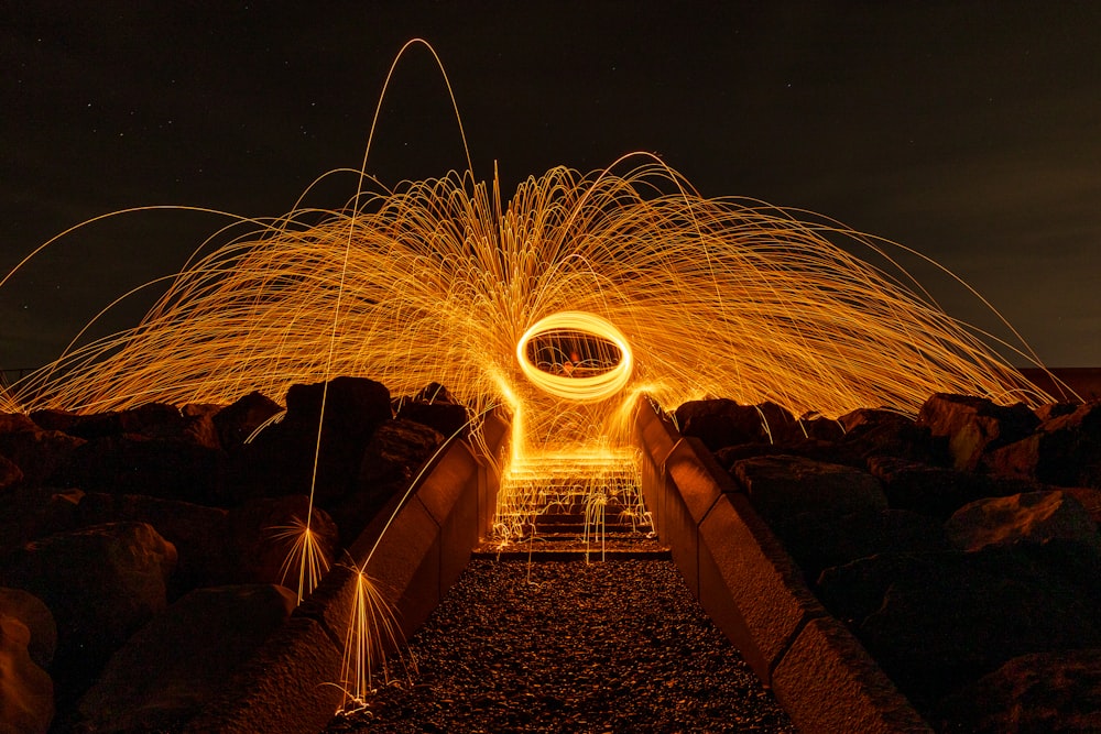 a steel wool spinning on a bridge at night