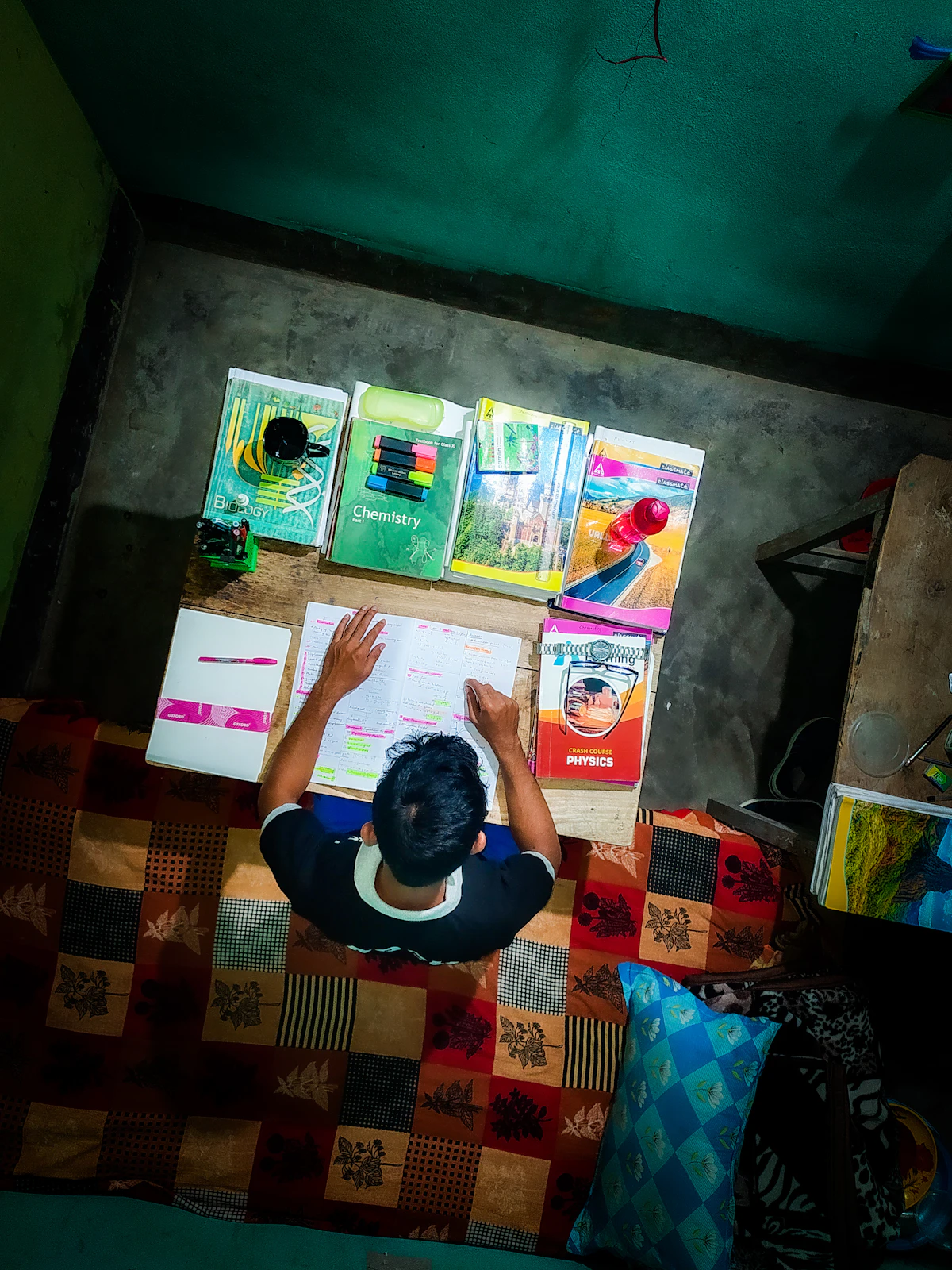 Estudiante rodeado de muchos libros mientras estudia