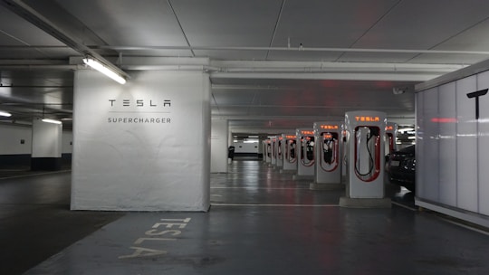 a parking garage with a row of electric cars