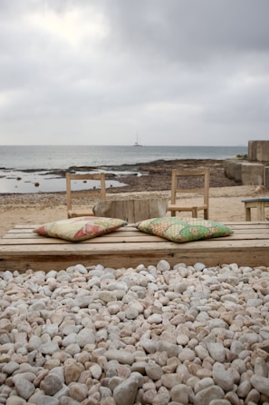 A serene meditation spot by the sea with cushions and soft blankets
