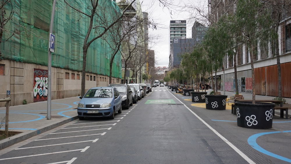 a street lined with parked cars next to tall buildings