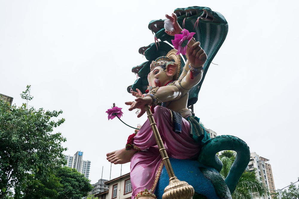 a statue of a man riding a dragon holding a flower