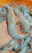 Close-up of a smiling aquaculture farmer holding a basket of fresh prawns beside a clear blue pond.