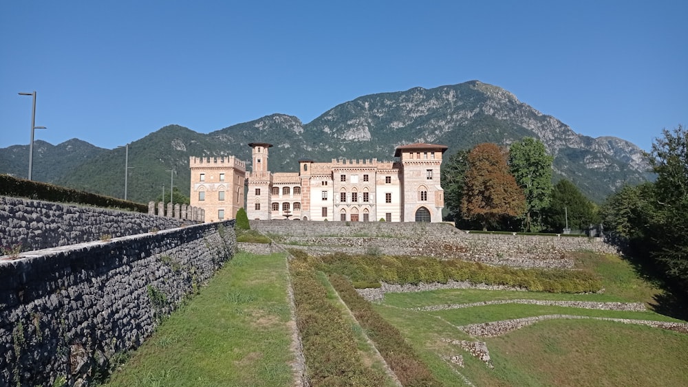 a large castle like building sitting on top of a lush green field