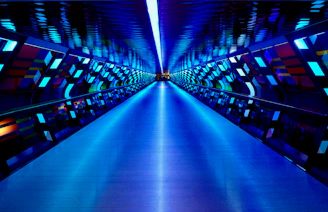 a very long hallway with a blue light at the end