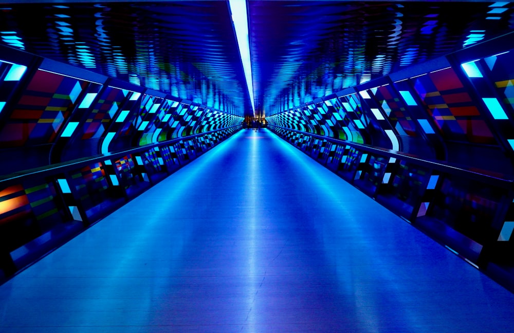 a very long hallway with a blue light at the end