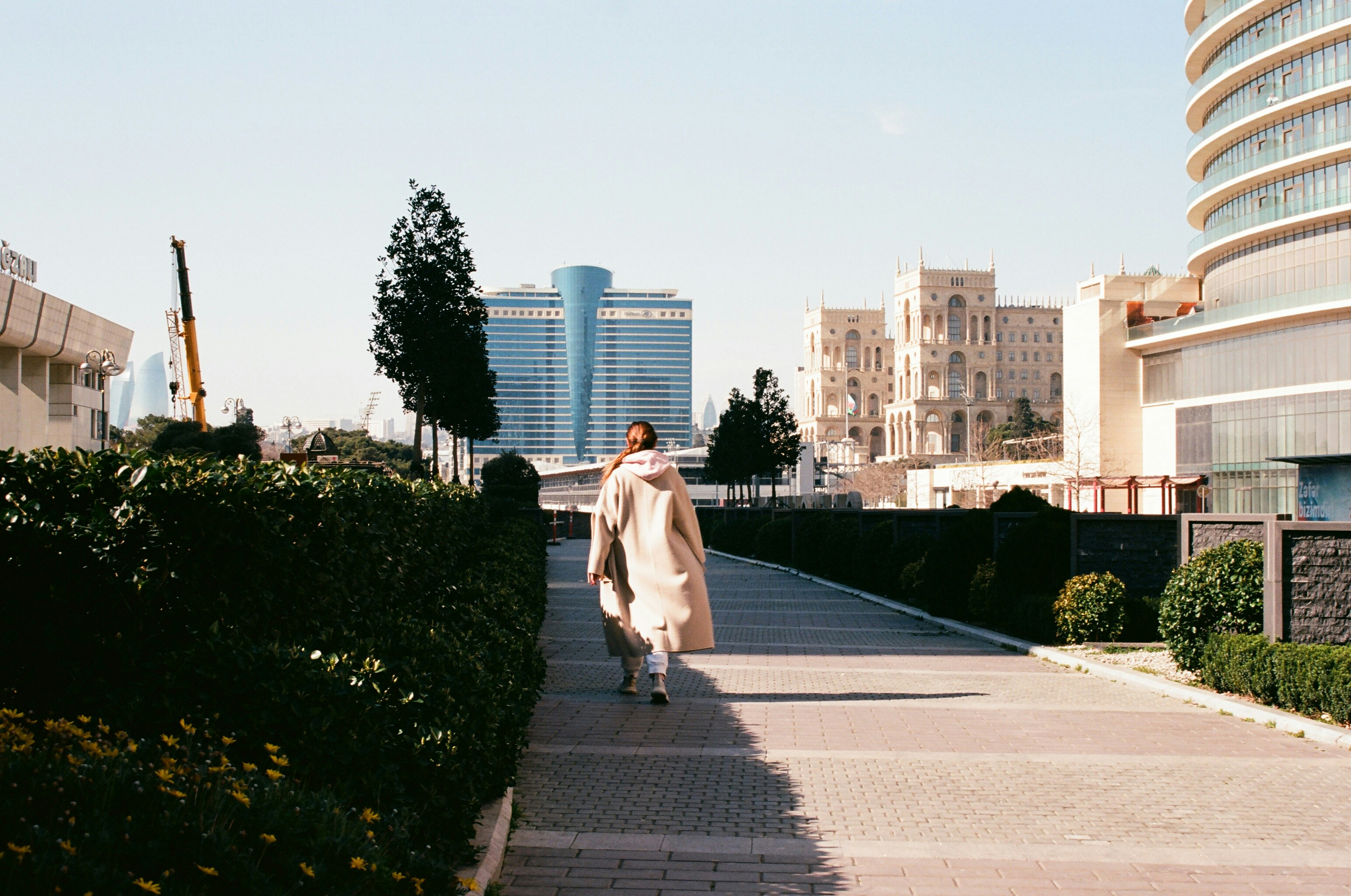 a woman walking down a sidewalk in a city
