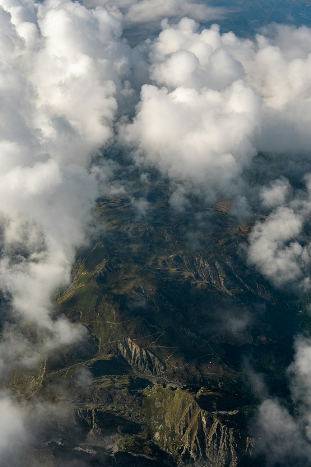 an aerial view of a mountain range covered in clouds