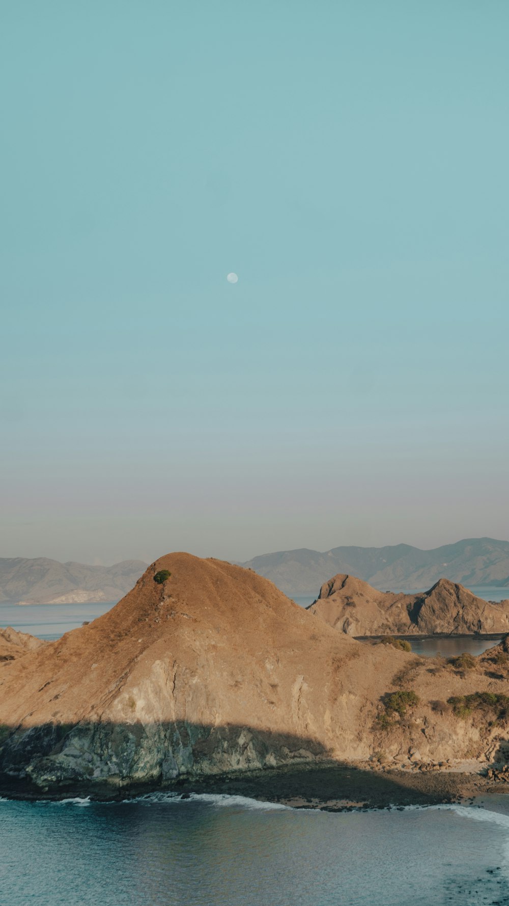 a large body of water with a mountain in the background