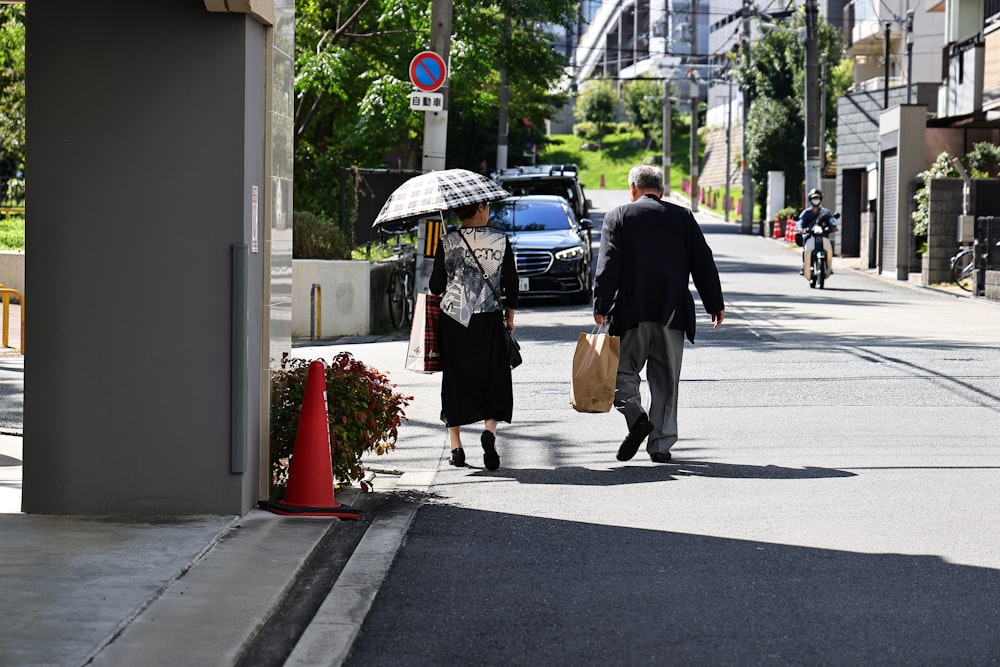 a man and a woman walking down a street holding an umbrella