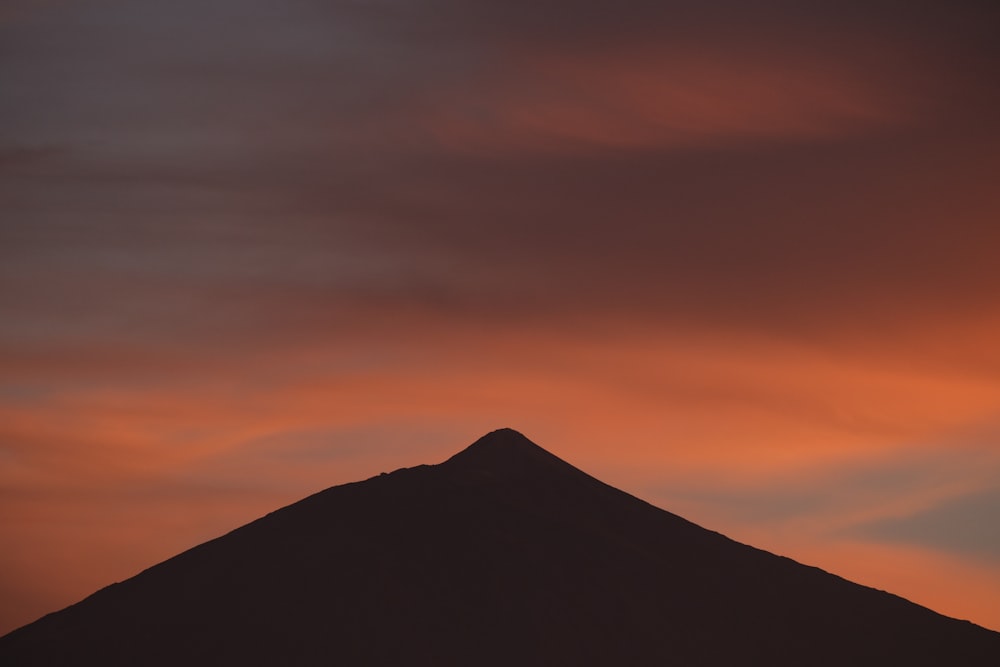 a mountain with a red sky in the background