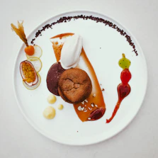 Elegant presentation of a fusion dessert featuring tropical fruits and delicate sauces.